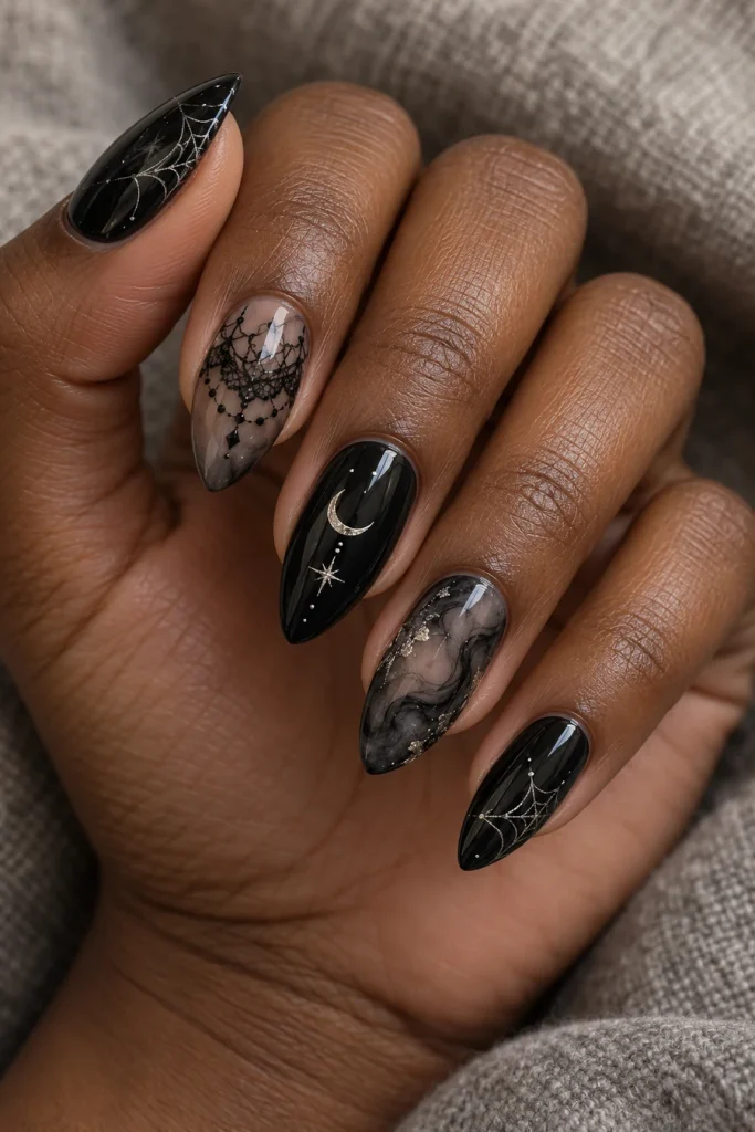 Almond nails with black lace-like artwork, fine silver webs, a silver crescent and smoky black marbling.