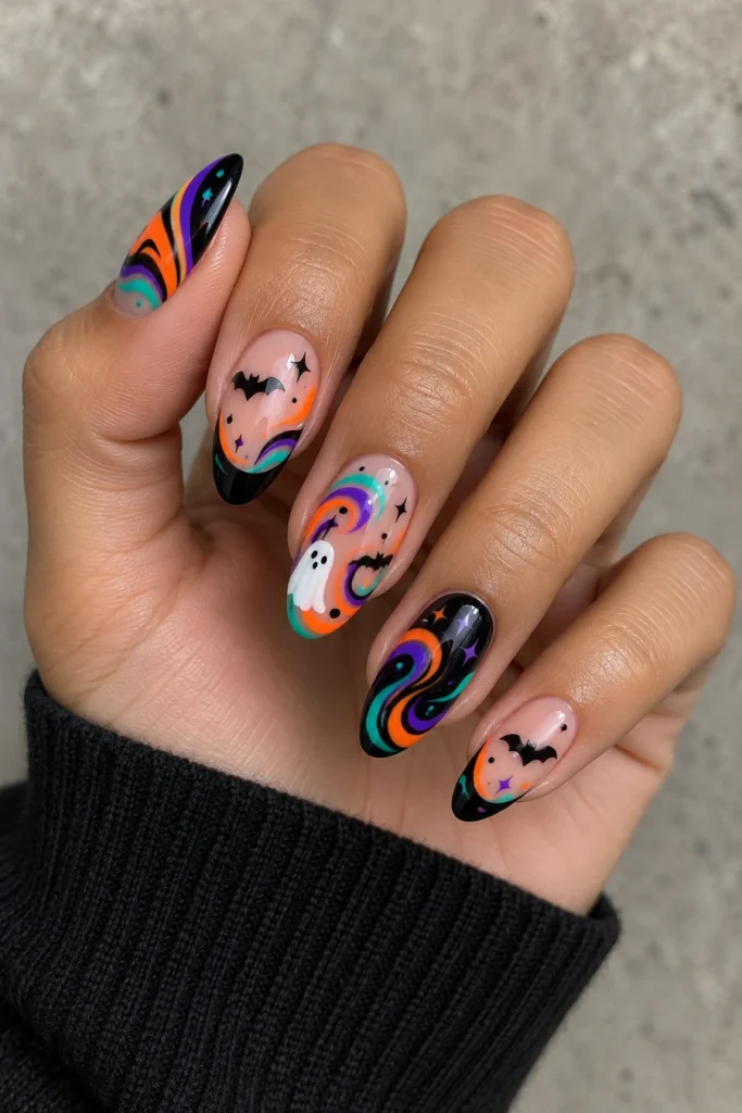 A hand with almond nails featuring neon violet, orange and turquoise swirls, black bats, white ghosts, stars and black tips.